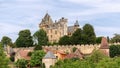 Chateau de Montfort on hill top and villageÃÂ huddled belowÃÂ substantial ramparts of castle with attractive houses in Dordogne Royalty Free Stock Photo